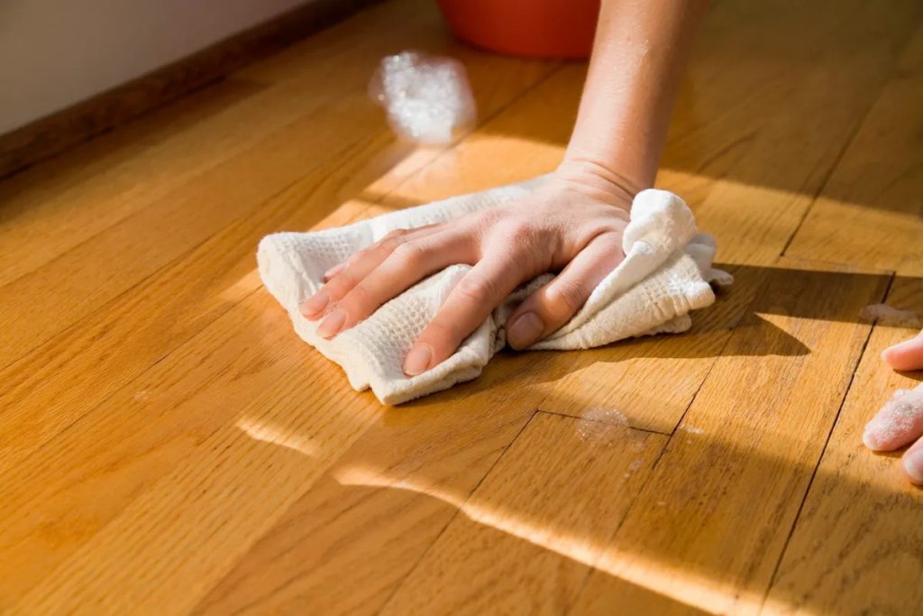 Common wooden floor cleaning mistakes while wiping hardwood floor with a wet cloth