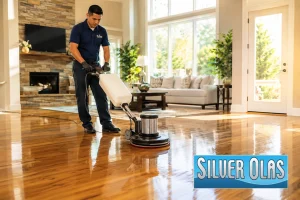 Professional hardwood floor polishing service restoring shine in a modern residential living room.