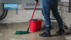 Professional basement flood cleanup services with a technician mopping a wet floor.