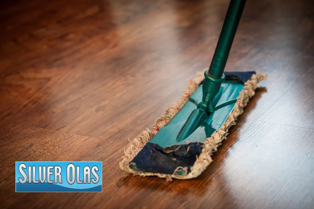 A professional floor scrubbing machine being used by a technician to deep clean and restore the shine of a hardwood floor.