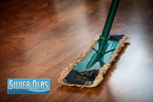 A professional floor scrubbing machine being used by a technician to deep clean and restore the shine of a hardwood floor.
