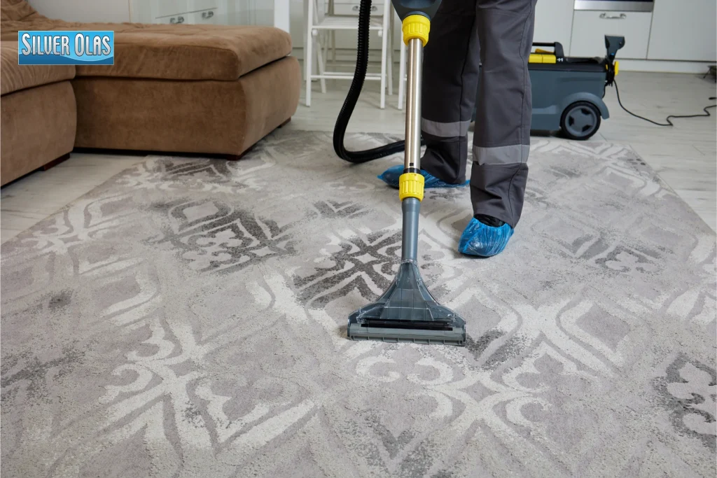Professional technician using extraction wand on rug for Steam Carpet Cleaning service.