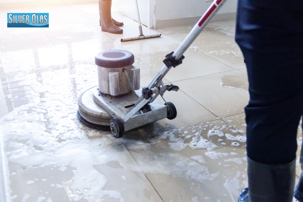 Professional floor scrubber machine performing deep tile and stone cleaning on tile floor.