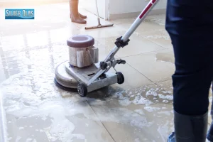 Professional floor scrubber machine performing deep tile and stone cleaning on tile floor.